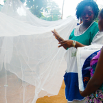 An image depicting a female holding a baby, accompanied by another woman standing nearby.